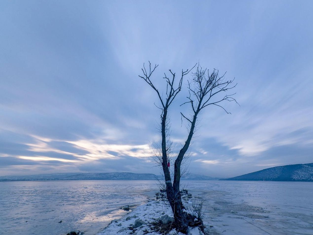 Una línea de orilla vista a primera luz sobre un lago de montaña
